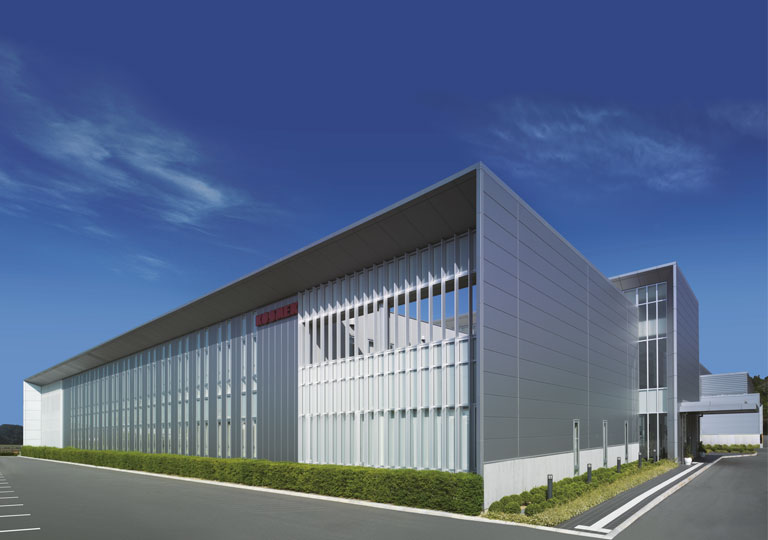 KOSMEK modern headquarters building under blue sky, highlighting advanced engineering and global leadership in automation.