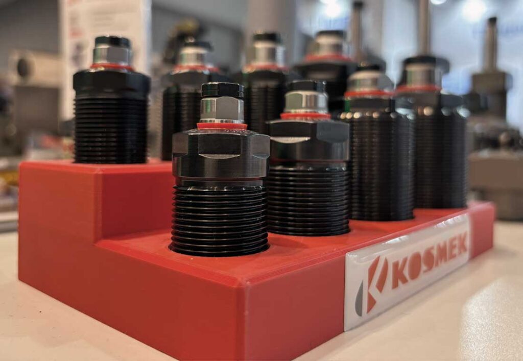 Close up of KOSMEK TNE work support models arranged on a red fixture, highlighting the compact and rigid design.
