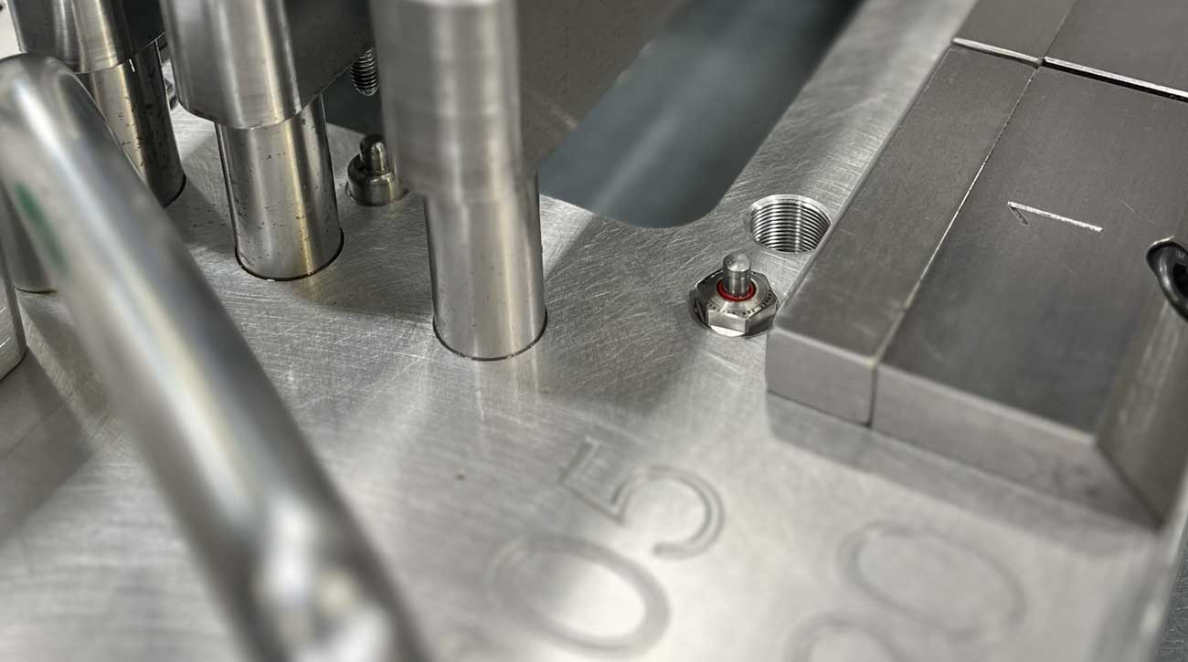 Nahaufnahme eines KOSMEK High-Power pneumatischen Abstützelements in einer RD Castings Bearbeitungsvorrichtung zur stabilen Bauteilabstützung.