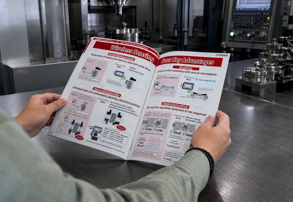 Open KOSMEK Work Clamping Systems Catalog showing Wireless Sensing Technology in front of a machine tool.