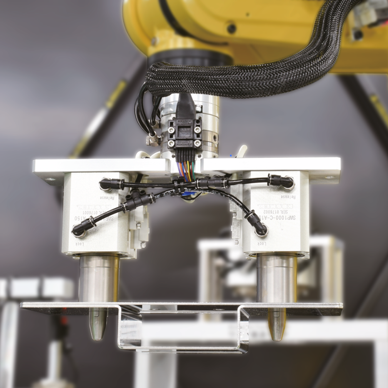 Robot holding a formed sheet metal component through two holes using KOSMEK SWP locating pin clamps
